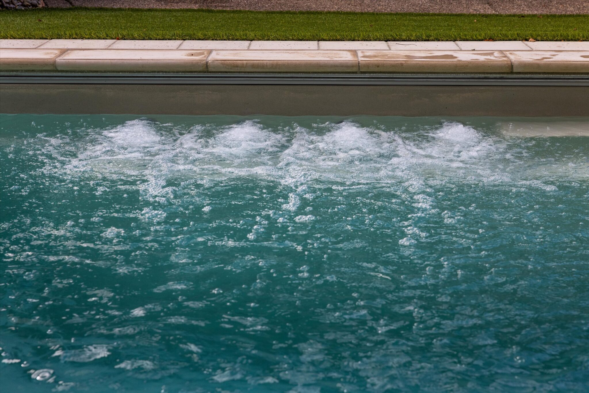 Front view of 4 therapeutic jets running on deep end bench of Imagine Pools Illusion 40 in beach sand in Prospect, KY.