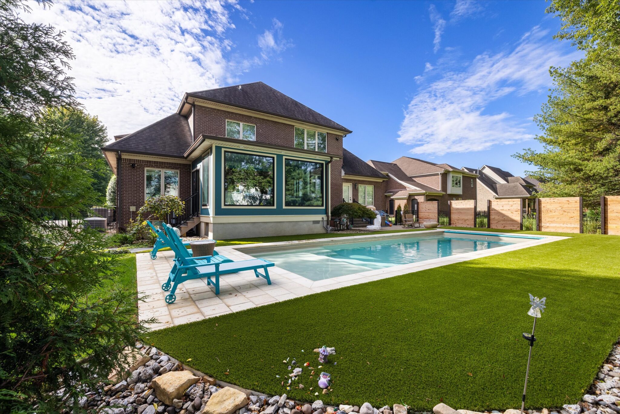 Wide angle shoot of Imagine Pools Illusion 40 in beach sand with paver coping and turf in Prospect, KY.